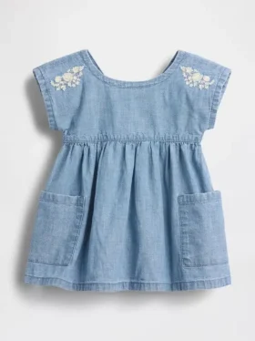 Baby-jeetje met geborduurde denimzakken in de jurk