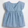 Baby-jeetje met geborduurde denimzakken in de jurk