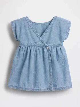 Baby-jeetje met geborduurde denimzakken in de jurk