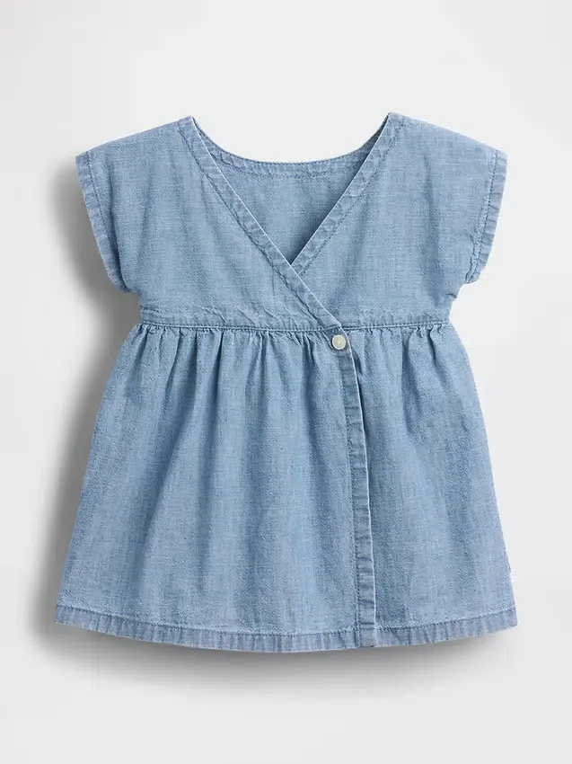 Baby-jeetje met geborduurde denimzakken in de jurk